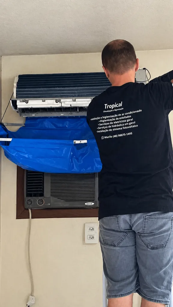 Técnico especializado em ar-condicionado atendendo cliente em Tubarão SC